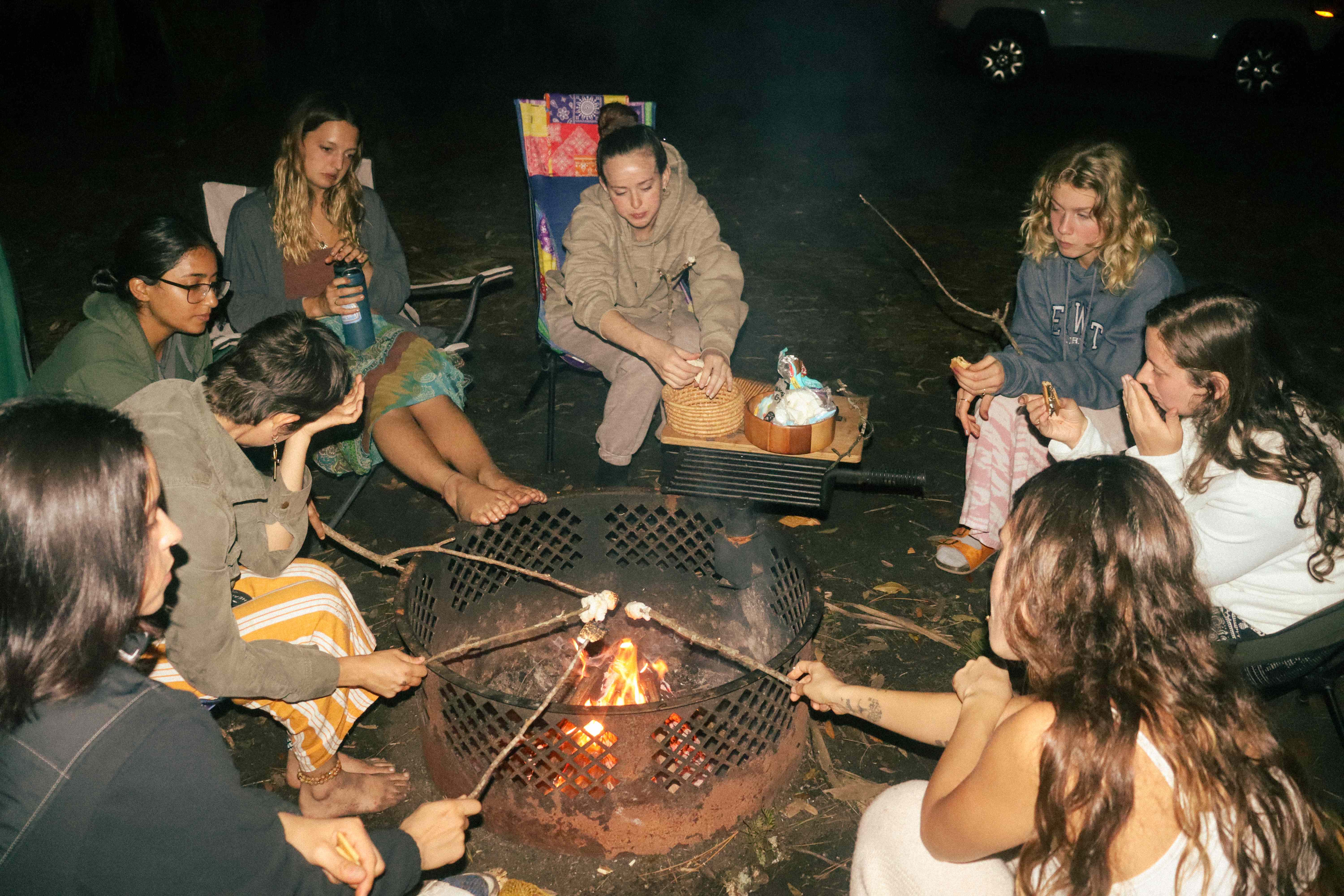 Evening fire circle with women gathered around bonfire