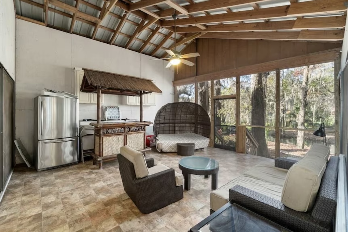 Screened porch with rustic beams and outdoor furniture
