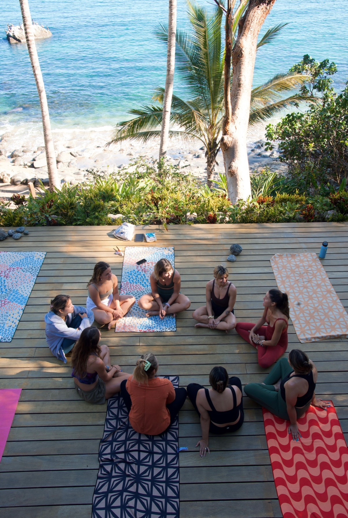 Aerial view of women in circle on beachfront deck