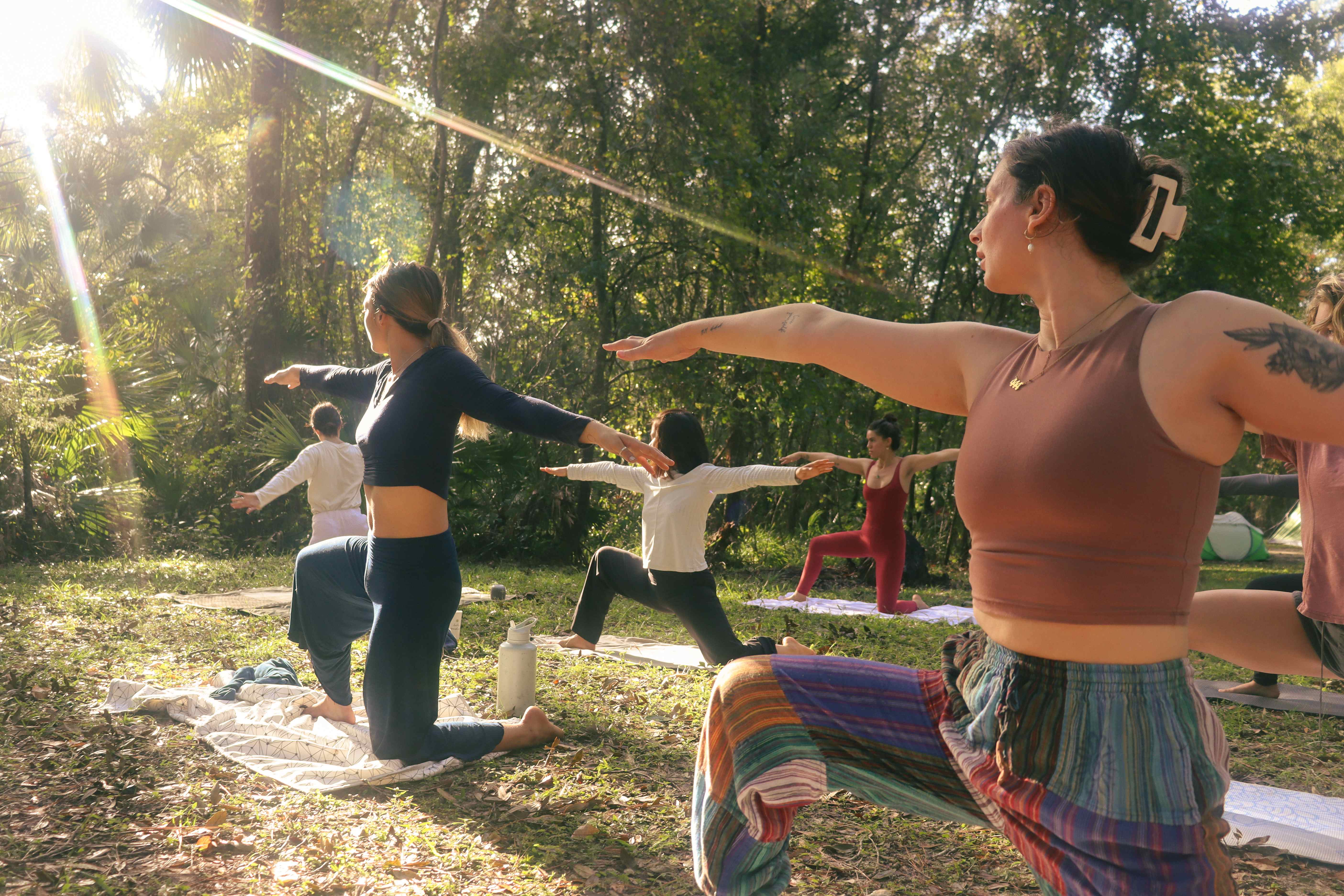 Women practicing yoga outdoors in golden sunlight